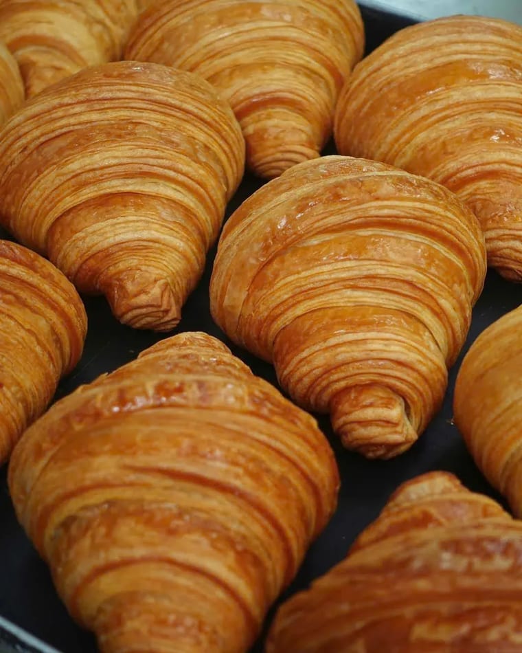 Bánh sừng bò bơ mới ra lò vàng ruộm xếp sát nhau trên khay nướng tại Cam On Cafe.