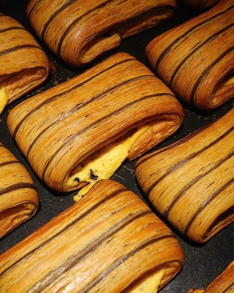Bánh sừng bò vằn sọc nhân kem mới ra lò xếp trên khay nướng tại Cam On Cafe.