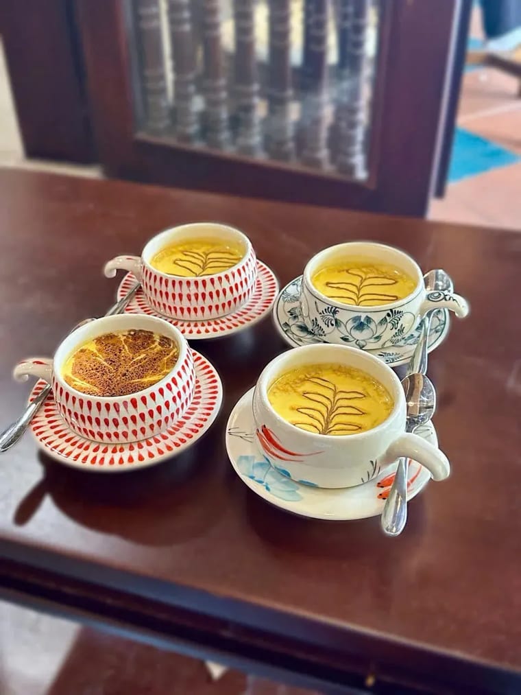 Bốn ly cà phê trứng Việt Nam vẽ hình lá, phục vụ trên đĩa sứ tại Cam On Cafe.