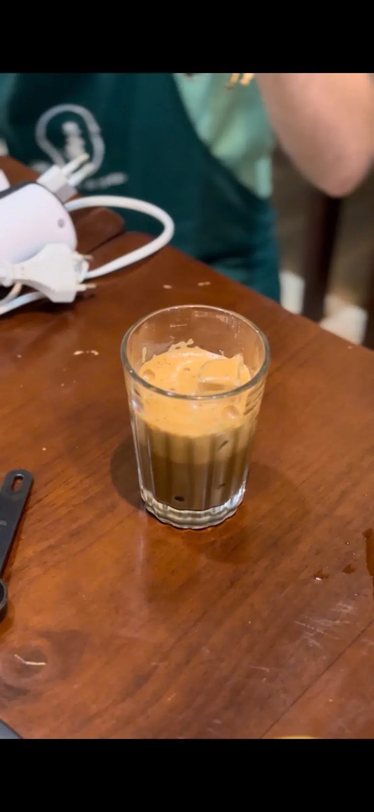 Ly cà phê đá Việt Nam với lớp bọt kem mịn, đặt trên bàn gỗ tại Cam On Cafe.