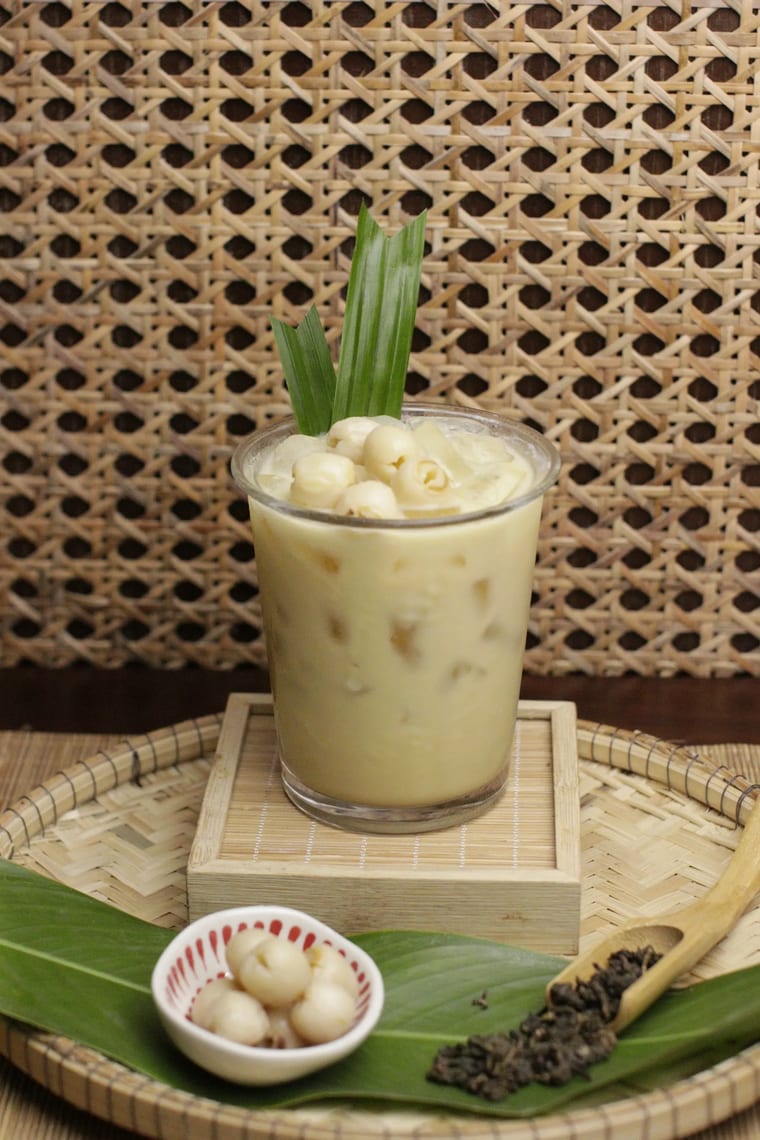 Ly trà sen đá trang trí lá dứa, đặt trên khay tre.